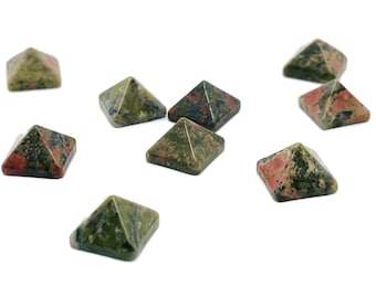 Peut inclure: Neuf pierres pyramidales tachetées de vert, de rouge et de noir. Les pierres sont disposées de manière dispersée sur un fond blanc.