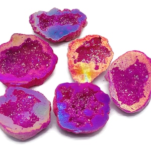 May include: Six iridescent pink and purple agate geode slices with a crystal interior. The geode slices are various sizes and shapes.