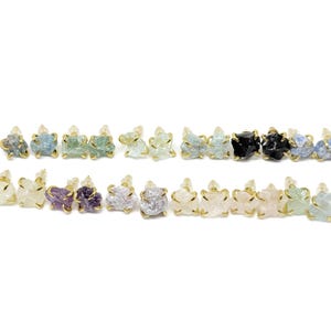 May include: A collection of 24 raw gemstone earrings. The earrings are made with gold-plated wire and feature a variety of colors, including blue, green, purple, and pink.