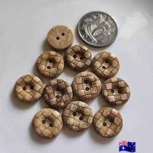 May include: A selection of wooden buttons in shades of brown, some with a checkered design. One button is plain with two holes. A coin is included for scale. The buttons are displayed on a white surface.