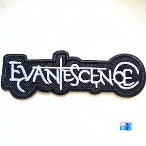 May include: A black embroidered patch featuring the word EVANESCENCE in white stylized lettering. The patch has a thick black border that follows the contour of the text, creating a cohesive shape. The embroidery is dense and textured throughout.