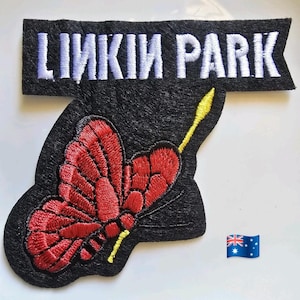 Puede incluir: Parche bordado con el nombre de la banda "LINKIN PARK" en letras blancas sobre un diseño de mariposa roja con detalles amarillos. El parche está sobre un fondo negro. Una bandera australiana está en la esquina.