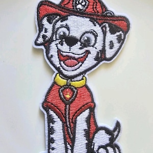 Könnte beinhalten: Gestickter Aufnäher mit einem lächelnden Cartoon-Hund in roter Feuerwehruniform und Helm. Der Hund hat schwarze Flecken, einen gelben Kragen und ein Abzeichen. Der Aufnäher ist weiß mit schwarzen Nähten.