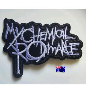 May include: A black embroidered patch featuring the text My Chemical Romance in a stylised, light purple font. The lettering is arranged in two lines with a jagged, irregular border. A small Australian flag emoji is positioned below the patch.
