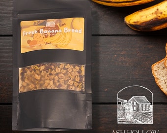 May include: A black pouch with a clear window showing loose leaf tea. The pouch has a label that says "Fresh Banana Bread" with a picture of bananas. The label also has the text "Ash Hollow Tea Company".