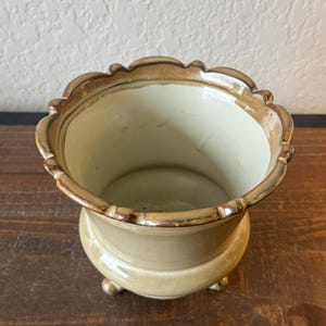 May include: A set of three ceramic mugs with a speckled, matte finish. The mugs are in shades of cream, light gray, and dark gray. Each mug has a simple, minimalist design and a rounded handle.