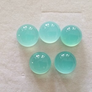May include: Six round, smooth, light blue cabochon gemstones.