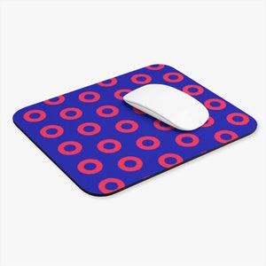 May include: A blue mouse pad with a repeating pattern of red donuts. A white computer mouse is on top of the mouse pad.