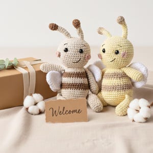 Two organic bee plush toys packaged together in a small kraft gift box, artisan eco baby present.