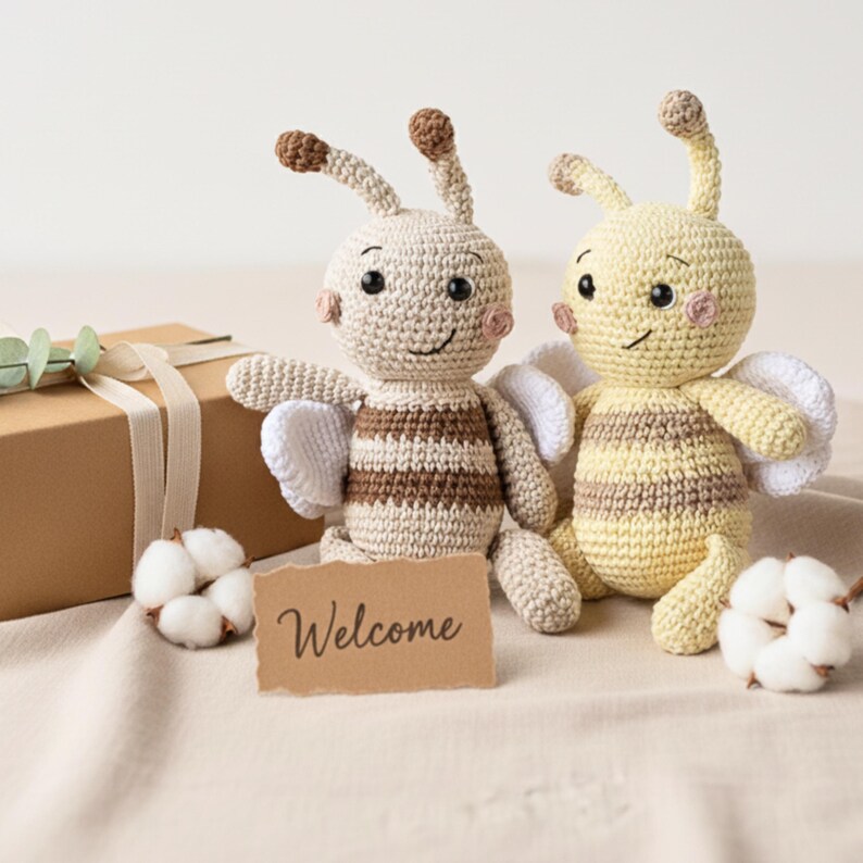 Two organic bee plush toys packaged together in a small kraft gift box, artisan eco baby present.