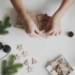 Artisan hands wrapping sustainable baby gift with cotton plush toy