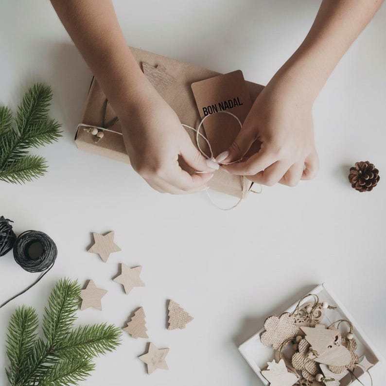 Artisan hands wrapping sustainable baby gift with cotton plush toy