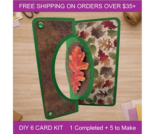 May include: A handmade greeting card featuring a green frame, a textured brown panel with two green gems, and a central oval cutout displaying a dimensional orange and red oak leaf. The right side of the card shows a pattern of colorful autumn leaves.