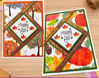 May include: Two rectangular greeting cards featuring autumn themes. The left card displays colorful trees, while the right card shows pumpkins and leaves. Both cards have a central diamond-shaped white panel with the text Happy fall and glittery borders.