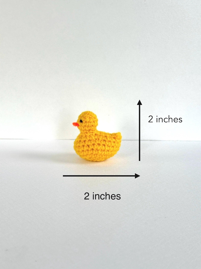 May include: A small yellow crocheted rubber duck measuring 2 inches in length and 2 inches in height.