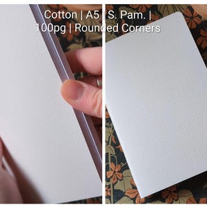 May include: A white notebook with a textured cover, featuring rounded corners and A5 size. The text on the image reads: Cotton | A5 | S. Pam. | 100pg | Rounded Corners. The notebook has 100 pages and is made of cotton material.