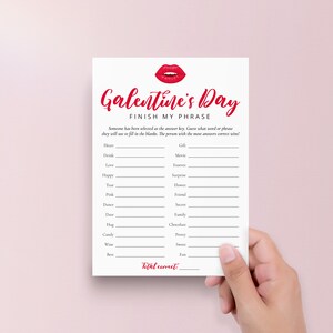 May include: A printable Galentine's Day game card with red lips at the top and the text "Galentine's Day Finish My Phrase". The card has a list of words to complete phrases, such as "Heart", "Drink", "Love", "Happy", "True", "Pink", "Dance", "Date", "Hug", "Candy", "Wine", "Best".