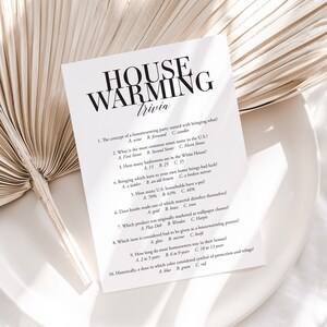 May include: A printable housewarming trivia game with 10 questions. The questions are about common housewarming party traditions, like bringing wine, the most common street name in the US, and the number of bathrooms in the White House.