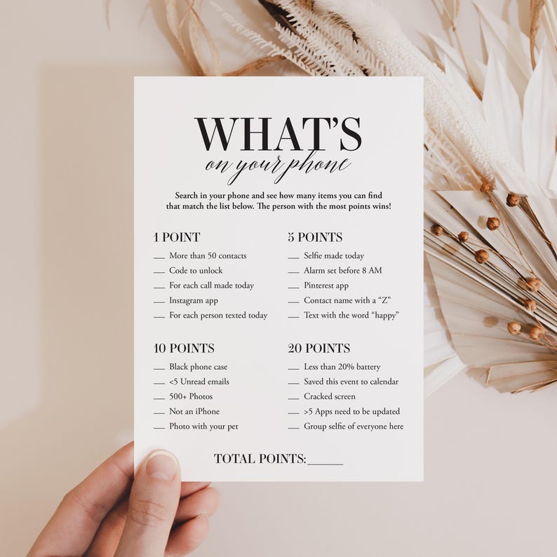 May include: A white card with black text that says "WHAT'S on your phone" and lists a game to play with friends. The game involves searching your phone for items on the list and earning points for each item found. The person with the most points wins.
