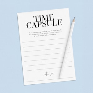 May include: A white card with black text that reads "TIME CAPSULE". The card has lined spaces for writing a message to a one-year-old boy to be read when he turns 18. The card also has the text "with love."