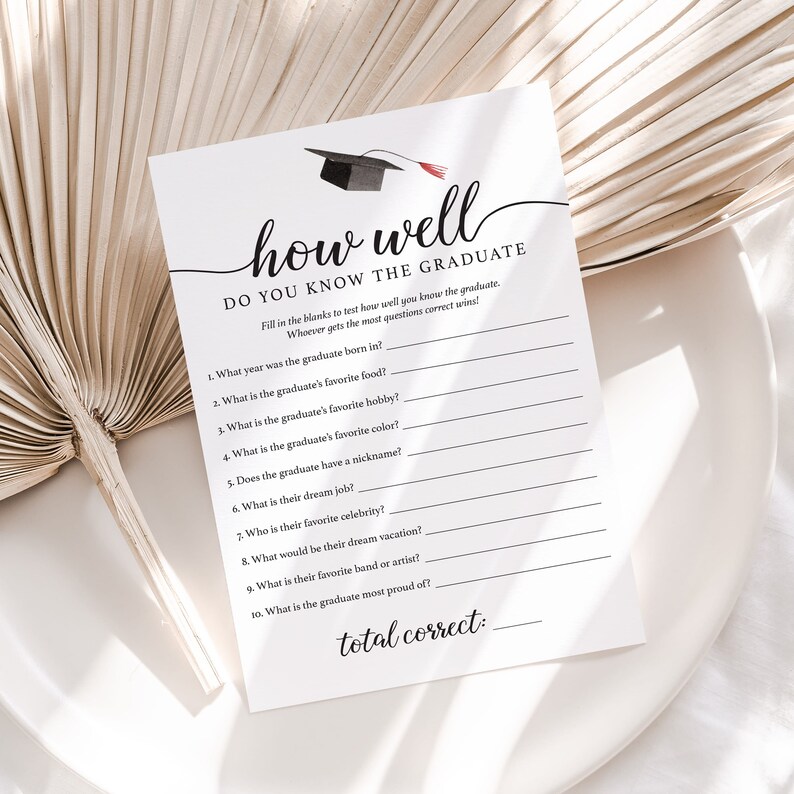 May include: A white graduation party game card with the text "how well DO YOU KNOW THE GRADUATE". The card includes fill-in-the-blank questions about the graduate's favorite things. A black graduation cap illustration is at the top.