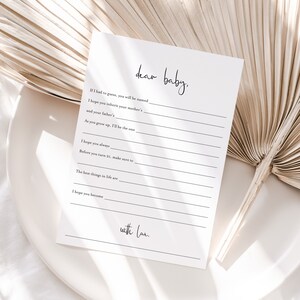 K&ouml;nnte beinhalten: Eine wei&szlig;e Karte mit schwarzem Text, der "Liebes Baby" lautet. Die Karte hat leere Zeilen zum Schreiben eines Briefes an ein Baby. Der Text "mit Liebe" steht am unteren Rand der Karte.