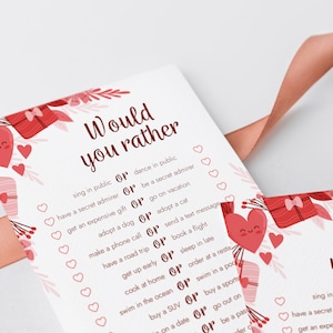 Peut inclure: Une carte rose et blanche avec le texte "Would you rather" en rouge. La carte pr&eacute;sente une s&eacute;rie de questions avec deux choix chacune, comme "chanter en public ou danser en public" et "avoir un admirateur secret ou &ecirc;tre un admirateur secret". La carte est d&eacute;cor&eacute;e de c&oelig;urs et de bo&icirc;tes cadeaux rouges.