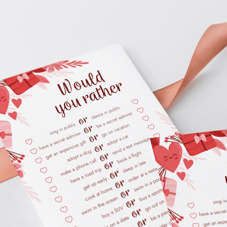 Peut inclure: Une carte rose et blanche avec le texte "Would you rather" en rouge. La carte pr&eacute;sente une s&eacute;rie de questions avec deux choix chacune, comme "chanter en public ou danser en public" et "avoir un admirateur secret ou &ecirc;tre un admirateur secret". La carte est d&eacute;cor&eacute;e de c&oelig;urs et de bo&icirc;tes cadeaux rouges.