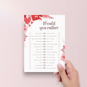 Peut inclure: Une carte de jeu imprimable pour la Saint-Valentin avec le texte "Would you rather" et une liste de 14 questions avec deux choix chacune. La carte est d&eacute;cor&eacute;e de c&oelig;urs et de bo&icirc;tes cadeaux.