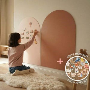Può includere: Due grandi lavagne magnetiche da parete a forma di arco, nei colori rosa tenue e terracotta. Le lavagne presentano una superficie liscia per attaccare vari piccoli magneti in legno a forma di animali e veicoli, con un set di magneti incluso.