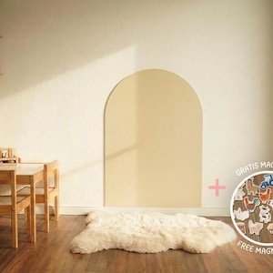May include: A large, beige, arch-shaped wall panel mounted on a wall, accompanied by a circular inset displaying a collection of small, colorful farm-themed wooden magnets with the text "GRATIS MAGNETSET" and "FREE MAGNET SET" printed on it.