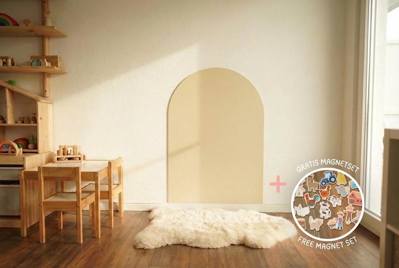 May include: A large, beige, arch-shaped wall panel mounted on a wall, accompanied by a circular inset displaying a collection of small, colorful farm-themed wooden magnets with the text "GRATIS MAGNETSET" and "FREE MAGNET SET" printed on it.