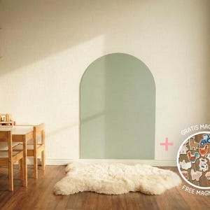 May include: A sage green arch-shaped wall board with a smooth surface, accompanied by a circular set of assorted farm-themed magnets featuring animals, a tractor, and a barn, labeled with the text GRATIS MAGNETSET FREE MAGNET SET.