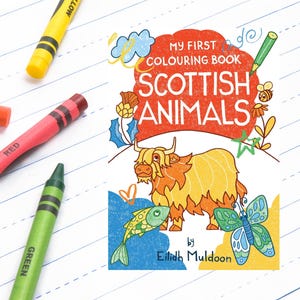 May include: A children's coloring book titled "My First Colouring Book Scottish Animals" with a cartoon illustration of a Highland cow. Crayons in yellow, orange, red, and green are scattered around the book on a white lined paper background.
