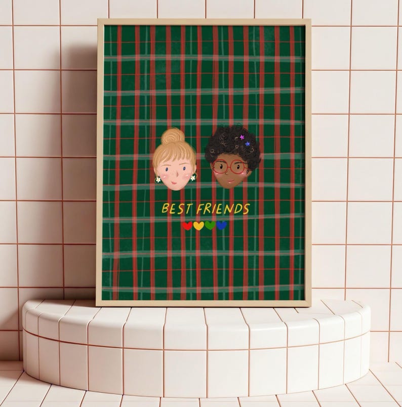 Puede incluir: Una impresi&oacute;n art&iacute;stica enmarcada con dos caras ilustradas de amigas sobre un fondo de cuadros verdes y rojos. Las palabras "BEST FRIENDS" est&aacute;n escritas debajo, con corazones coloridos. La obra de arte se exhibe sobre una superficie de baldosas blancas.