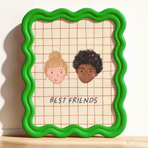 Könnte beinhalten: Ein gerahmter Druck mit zwei illustrierten Gesichtern von Freunden auf einem karierten Hintergrund. Der Rahmen ist hellgrün mit gewelltem Rand. Die Worte "BEST FRIENDS" sind in schwarzer Schrift am unteren Rand des Drucks geschrieben.
