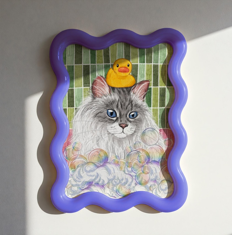 May include: An illustrated picture of a grey cat with blue eyes, wearing a yellow rubber duck on its head, surrounded by bubbles. The artwork is in a wavy purple frame, with a green and white grid background.