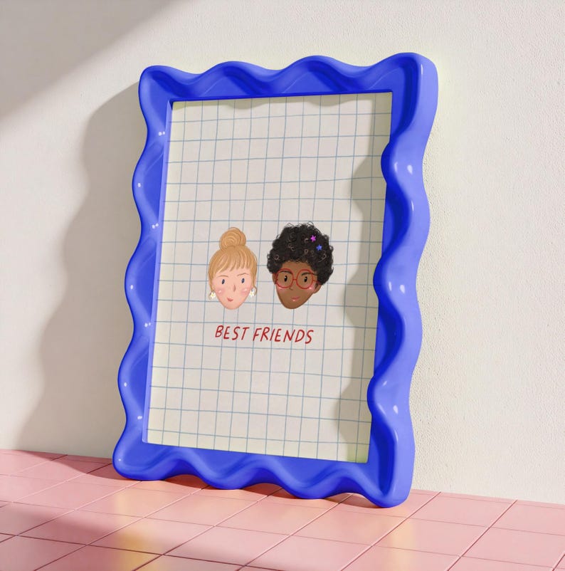 Puede incluir: Un marco de fotos azul con bordes ondulados que contiene un papel cuadriculado con dos caras ilustradas y el texto "BEST FRIENDS" en rojo. Las caras representan a dos mujeres, una rubia con un mo&ntilde;o y la otra con pelo rizado oscuro y gafas.