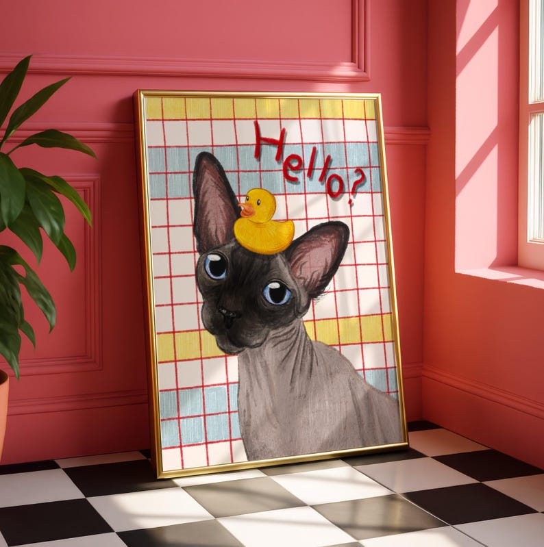 May include: A framed art print showing a Sphynx cat with blue eyes and a yellow rubber duck on its head. The background has a grid pattern with the word "Hello?" in red script.