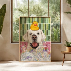 May include: A framed print depicting a white Labrador Retriever with a yellow rubber duck on its head, surrounded by bubbles. The dog has its tongue out, as if in a bath. The background has a green and white striped pattern.