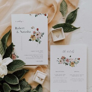 May include: Wedding invitation suite with floral designs. The invitation card features the names Robert & Natasha and the date August 23, 2023. The details card includes the reception and hotel information. The text reads "The wedding of Robert & Natasha, August twenty third, 2023, evening ceremony, half past 3 o'clock, the Saint Mary Church, 121 Downing Drive, Huntington, VA, Reception, 132 Bell Mar View, Providence, RI, Dress code: smart casual, We have included our ceremony on adults only, please no small children, Hotel, The Love Boat Hotel, Providence, RI, A block of rooms have been reserved under the Murphy wedding, Please RSVP online by Aug 23rd, at www.wedding.com/robertandnatasha"