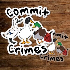 Puede incluir: Cuatro pegatinas de patos blancos y verdes con el texto "Commit Crimes" en ellas. Los patos sostienen varios objetos, incluyendo un cuchillo, una lata de gasolina y un cigarrillo. Las pegatinas están sobre un fondo de madera.