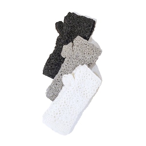 Puede incluir: Tres diademas de crochet en diferentes colores: negro, gris y blanco. Las diademas están hechas con un punto texturizado y tienen un diseño simple y elegante.