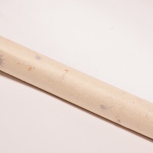May include: A roll of beige wrapping paper with a subtle floral pattern featuring small blue and orange flowers.