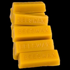May include: A stack of five yellow beeswax blocks, each labelled "BEESWAX".
