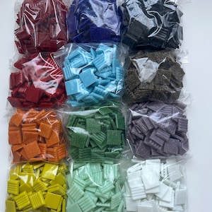 May include: Assortment of 10 bags of small, square mosaic tiles in various colours, including red, blue, green, purple, orange, yellow, and white. The tiles have a textured surface and are packaged in clear plastic bags.