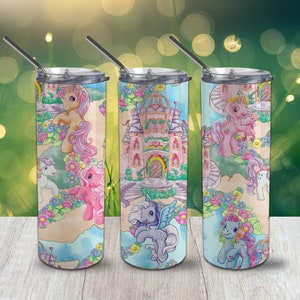 May include: Three stainless steel tumblers with lids and straws. Each tumbler features a different design with a pastel colour scheme of pink, blue, and purple. The designs include a castle, a unicorn, and a pony.