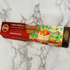 May include: A red and brown box of TrioColor 6 Grand Drawing Pencils. The box features a picture of a basket of apples and the text "ART COLLECTION". The pencils have an ergonomic triangle-shaped grip.