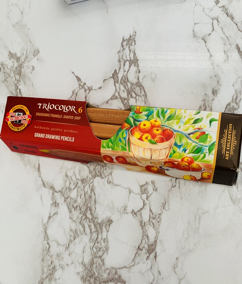 May include: A red and brown box of TrioColor 6 Grand Drawing Pencils. The box features a picture of a basket of apples and the text "ART COLLECTION". The pencils have an ergonomic triangle-shaped grip.