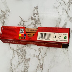 May include: A red box of Koh-I-Noor Triocolor 6 artist pencils. The box features the text "TRIOCOLOR 6" and "DRAWING/ILLUSTRATING/COLOURING/ERGONOMIC TRIANGLE-SHAPED GRIP". The pencils are oversized 0.41 inch pencils with bright, vibrant shades.
